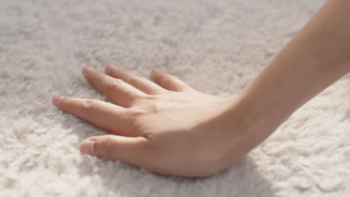 用手触摸柔软地毯的特写镜头，蓬松柔软舒适。
