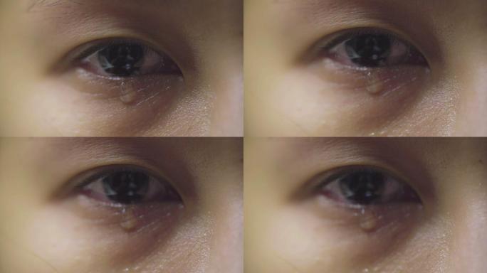 特写：眼泪从眼睛里流出，沿着脸颊划过。悲伤受虐的棕色眼睛哭泣的女性，亚洲模特。