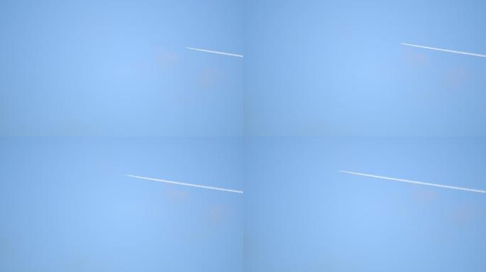 空中飞行的喷气式客机在晴朗的蓝天上留下了轨迹。