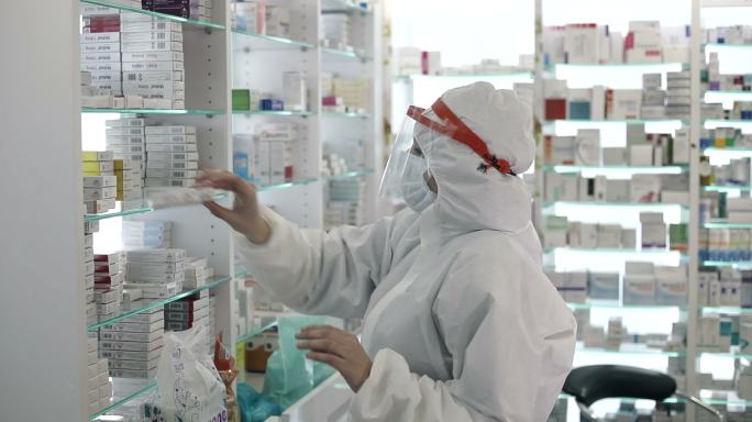 戴着口罩的女药剂师为患者准备药物