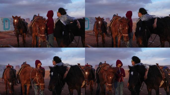 傍晚，在壮观的天空下，纪念碑谷的两个纳瓦霍小姐妹在照料马匹