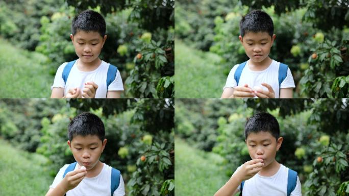 小男孩脱皮，在户外吃荔枝，竖起大拇指