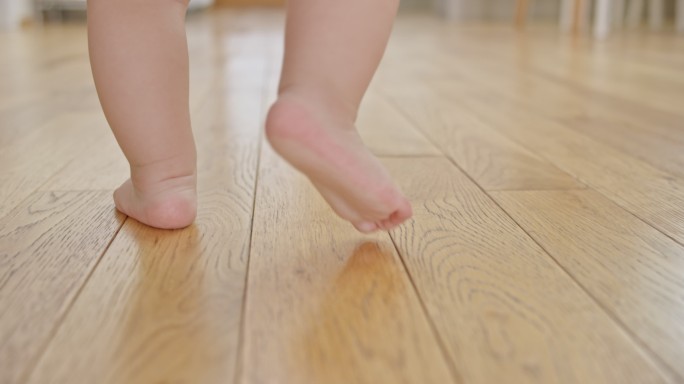 婴儿在木地板上慢吞吞地走着