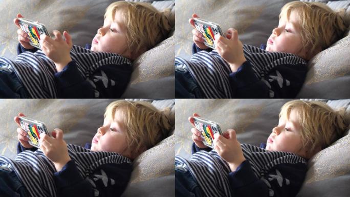 小男孩在床上使用智能手机