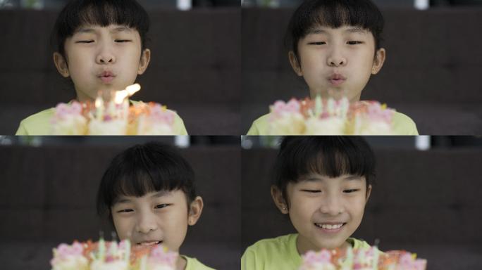 一个快乐的小女孩吹灭生日蛋糕上蜡烛的特写镜头。