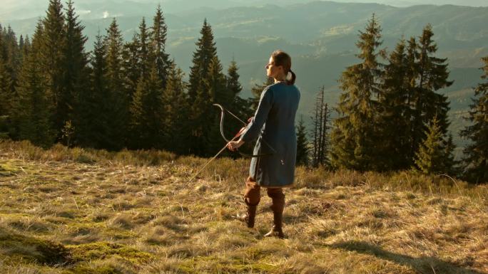 穿着服装的弓箭手在山林中狩猎