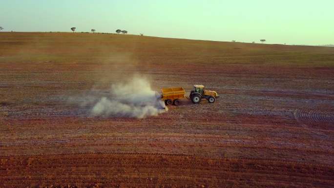 土壤施用石灰鸟瞰图-用于耕作和牧场施用石灰的农用拖拉机。使用土壤添加剂