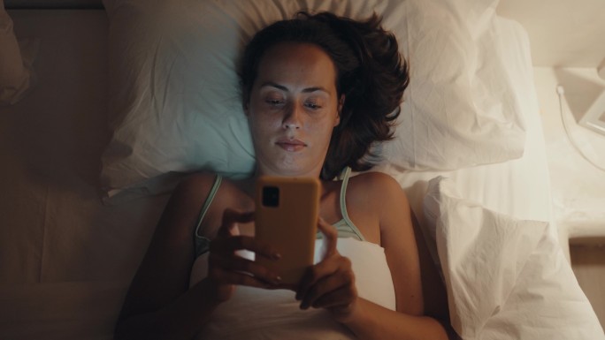 在床上浏览社交媒体的女性