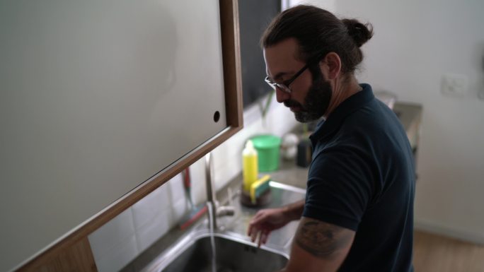 一个成年人在家洗碗的肖像