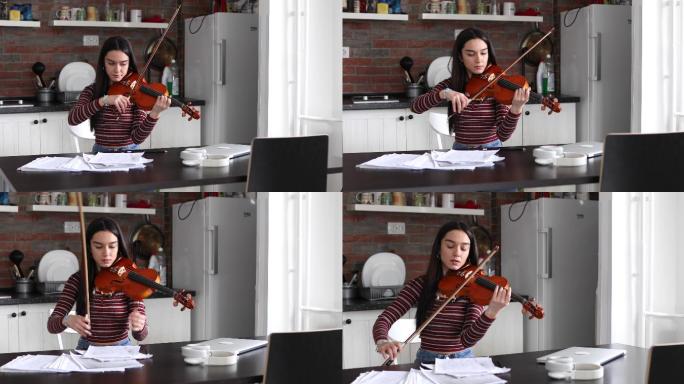 这位年轻的艺术家坐在厨房练习小提琴技巧。
