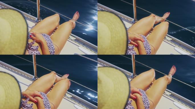 斯洛·莫（SLO-MO）一个女人一边晒日光浴一边把脚吊在船上