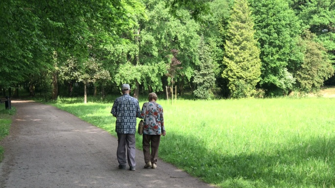 公园里的老年夫妇老年夫妻公园散步手拉手老