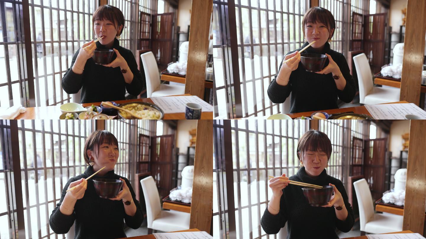 年轻女子在日本餐厅吃“Donabe Gohan”健康日本食品