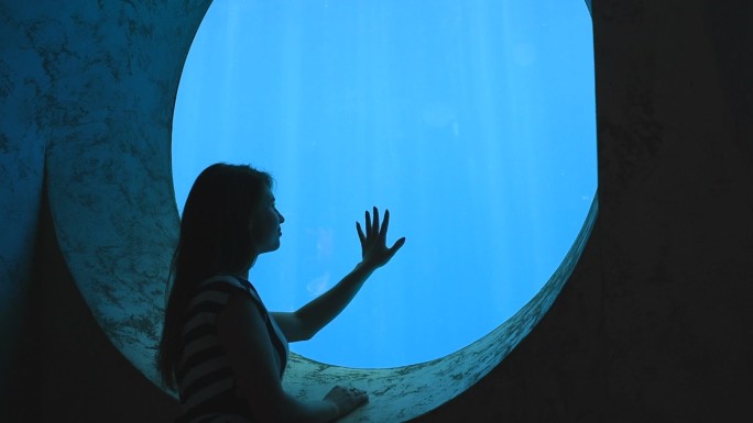 浪漫女孩欣赏水族馆的水下世界