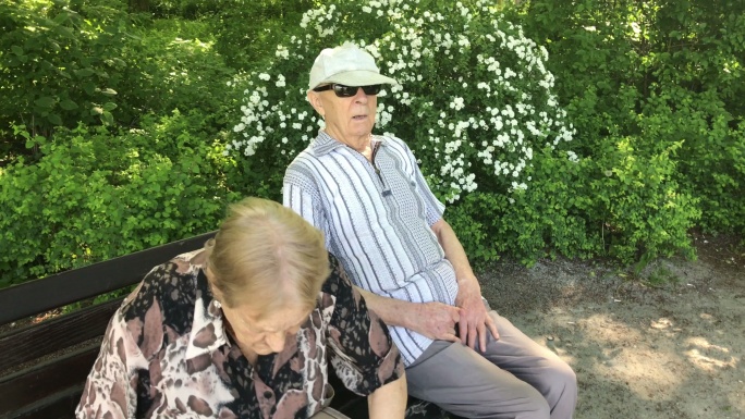 公园里的老夫妇坐在长凳上