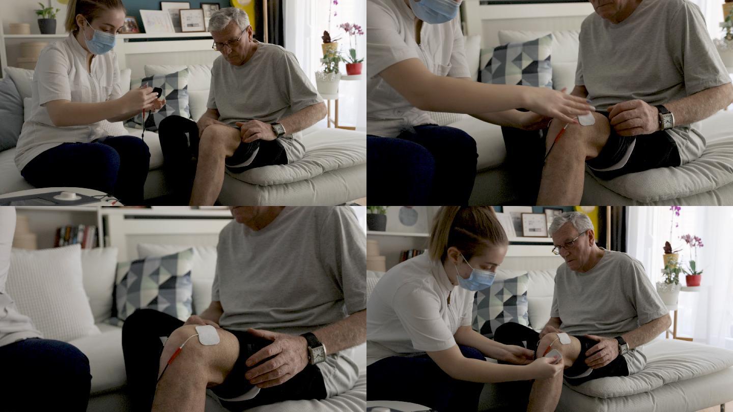 物理治疗师正在对一名老年男子的膝盖进行电刺激物理治疗