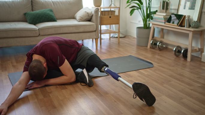 年轻男子在家开始锻炼前进行假腿伸展