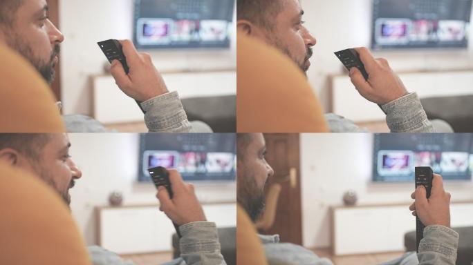 男性通过遥控器在家中使用语音切换电视频道