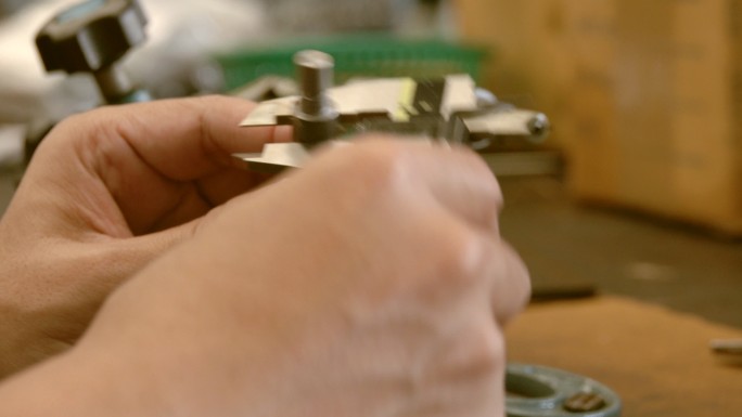 厂内人员用游标卡尺测量钢上的孔
