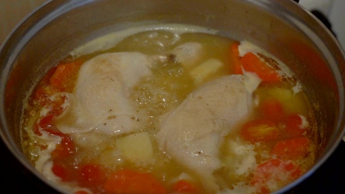用胡萝卜、西红柿和土豆慢动作烹饪鸡汤。