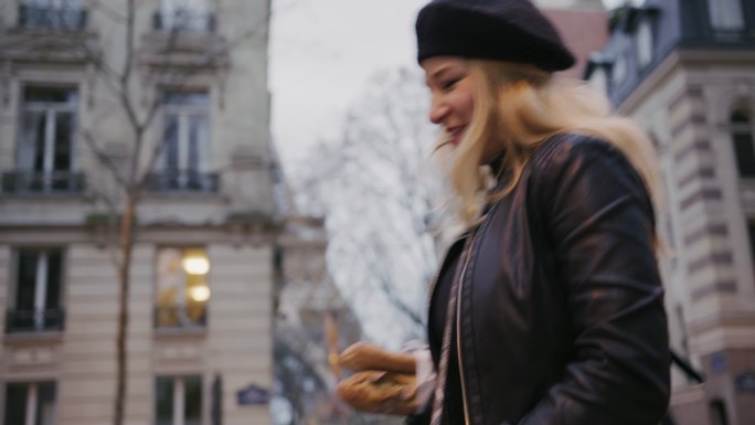 时尚的法国女人斯洛·莫沿着埃菲尔铁塔端着法式面包