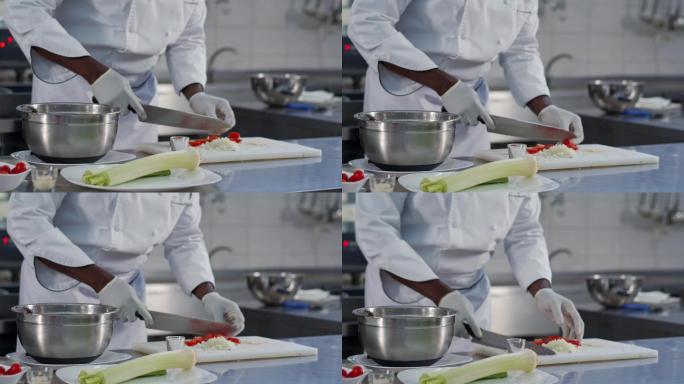 厨师用锋利的菜刀切樱桃番茄