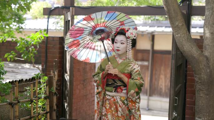 Maiko（艺妓在训练）在京都Gion的狭窄人行道上行走