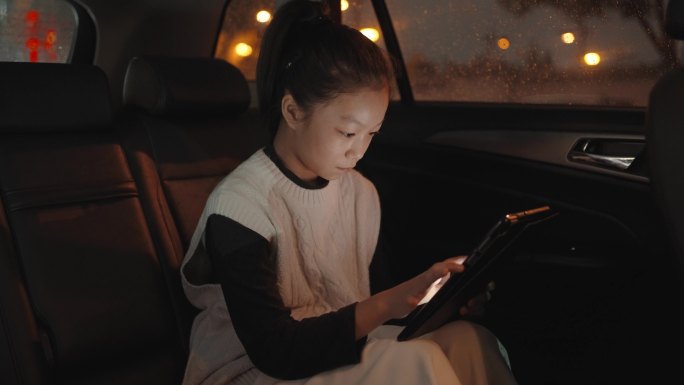 女孩在车内使用数字平板电脑
