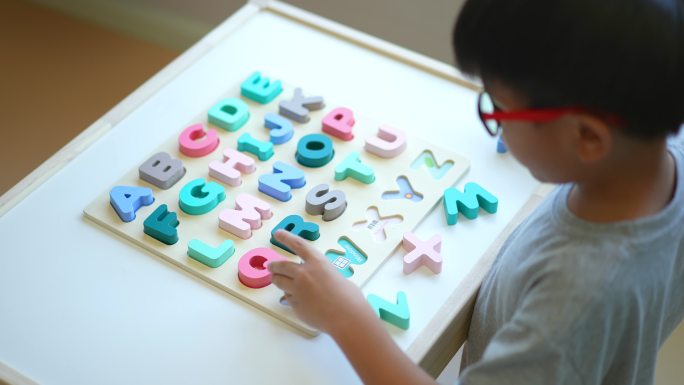 亚洲男孩学习英语字母和字母。返校概念