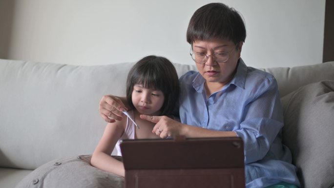 远程医疗远程健康亚洲华人母亲使用笔记本电脑与儿科医生就女儿疾病进行沟通