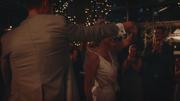 快乐的新娘和新郎在宾客中翩翩起舞