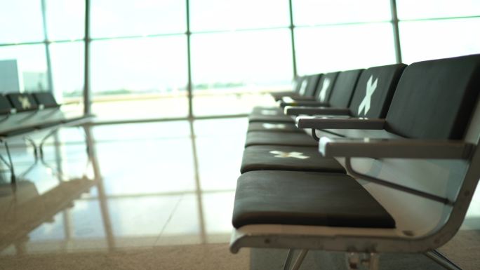 空空的机场候机室，椅子上有社交距离符号
