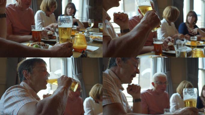 与朋友在酒吧午餐时喝啤酒的男人