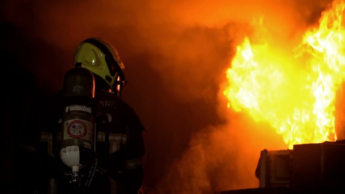 消防队员使用灭火器扑灭着火建筑物内的火灾