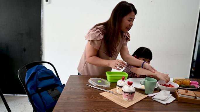 亚洲母女在餐桌旁准备健康的午餐盒