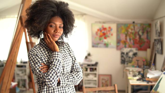 年轻的非裔美国女艺术家独自站在艺术工作室看着相机的4K视频肖像