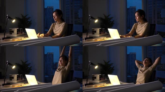 忙碌的亚洲女性晚上在黑暗的办公室工作