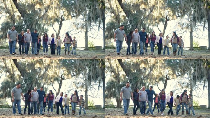多代西班牙裔家庭并肩在公园散步