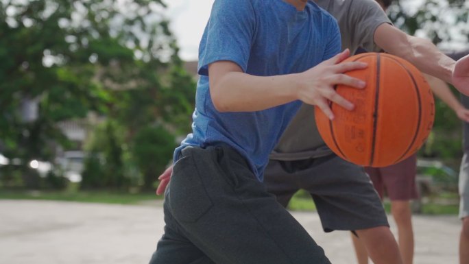 慢动作Z代亚裔中国少年在周末早上与朋友练习篮球比赛时投篮