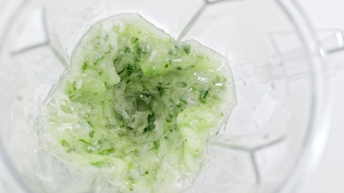 在搅拌机罐中搅拌绿色蔬菜