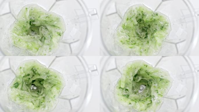 在搅拌机罐中搅拌绿色蔬菜