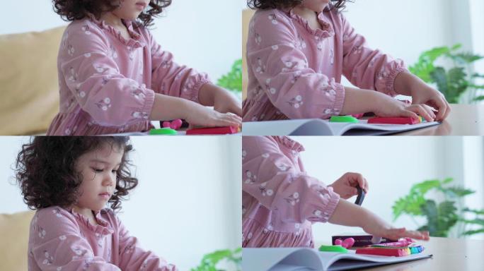 亚洲单身小女孩在客厅玩面团和画画