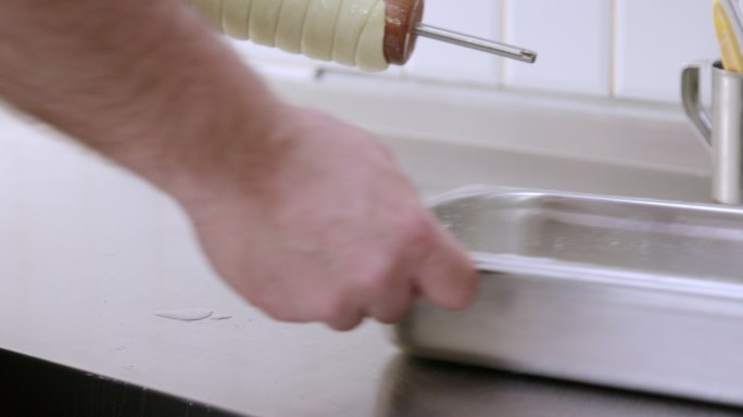 将烟囱蛋糕面团放在烤肉串上，涂油并涂刷