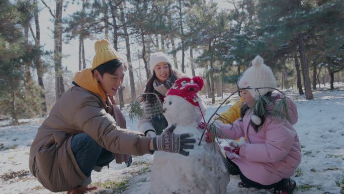 快乐家庭在雪地里堆雪人