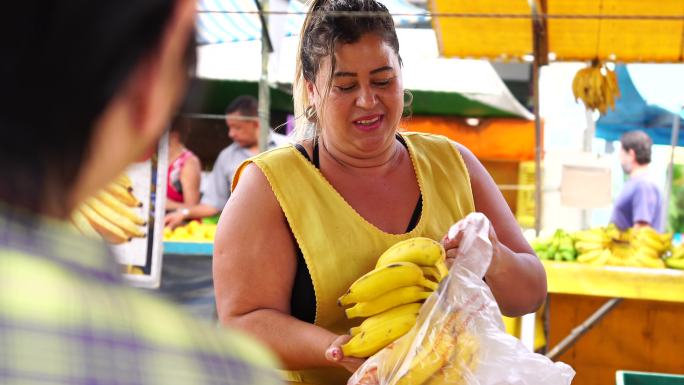 消费者在街市购买香蕉