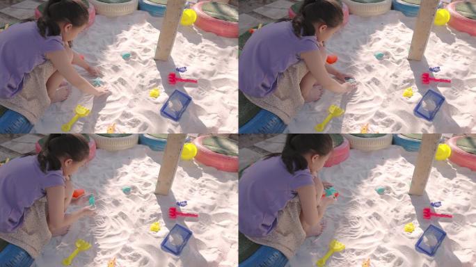 小女孩在沙箱里玩沙子