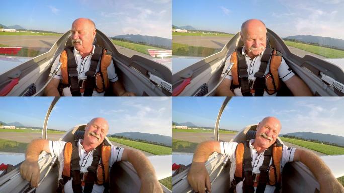 LD飞行员在滑翔机降落后打开驾驶舱，在阳光下大笑
