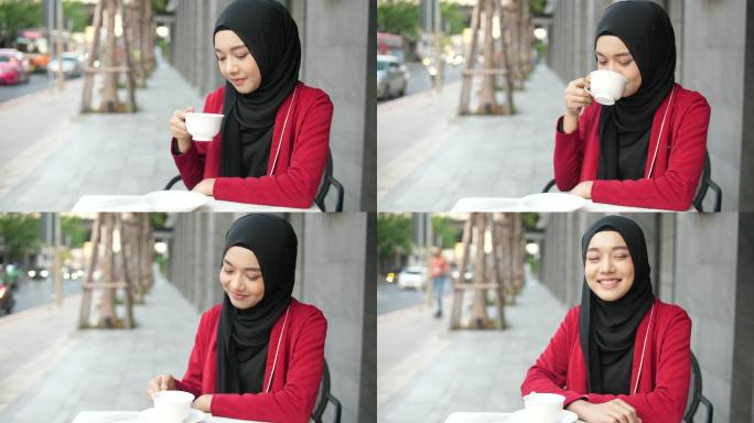 美丽的穆斯林妇女戴着头巾，在户外喝着咖啡，微笑着看着相机的肖像