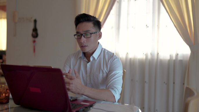 亚裔中国中年人在餐厅使用笔记本电脑工作