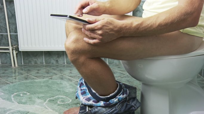 HD DOLLY：男人在厕所里使用数字平板电脑